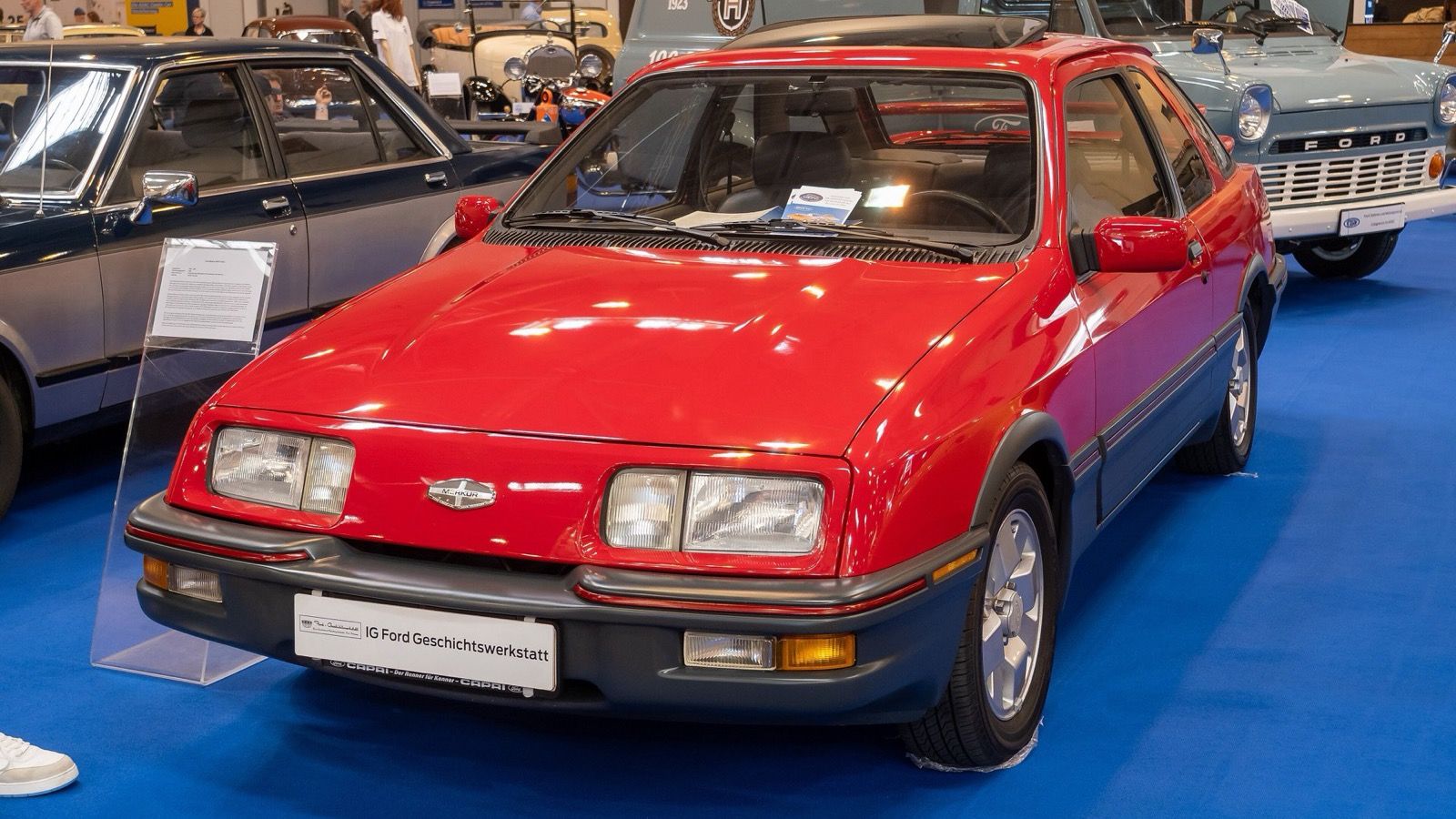Red Merkur XR4Ti, front three-quarter view, showing the twin-wing rear spoiler