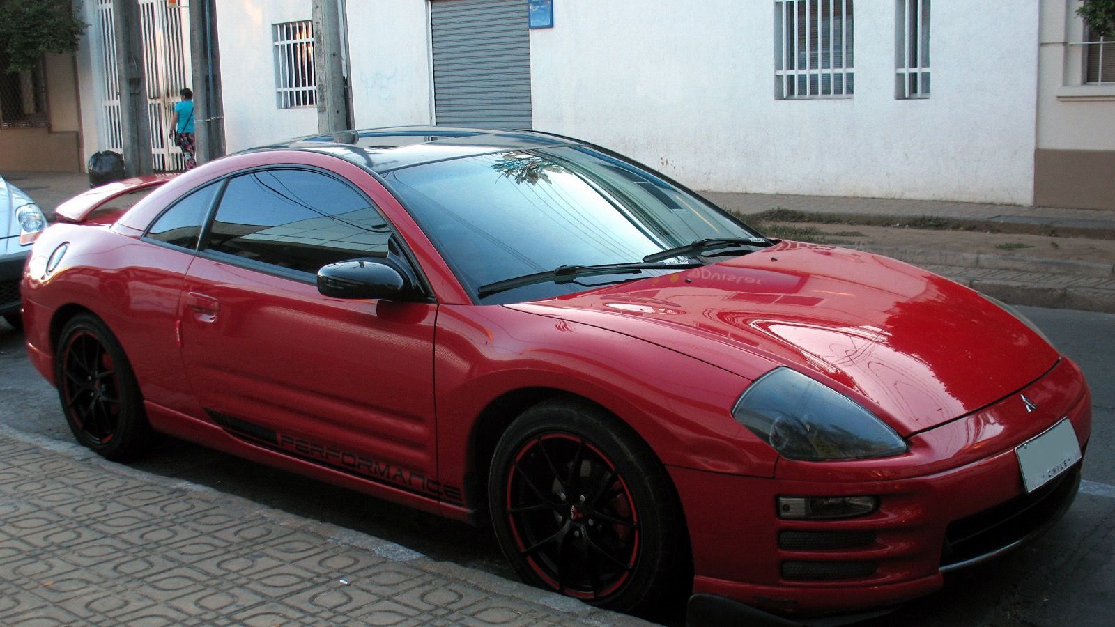 Red 2002 Mitsubishi Eclipse RS coupe parked on a street, front three-quarter view