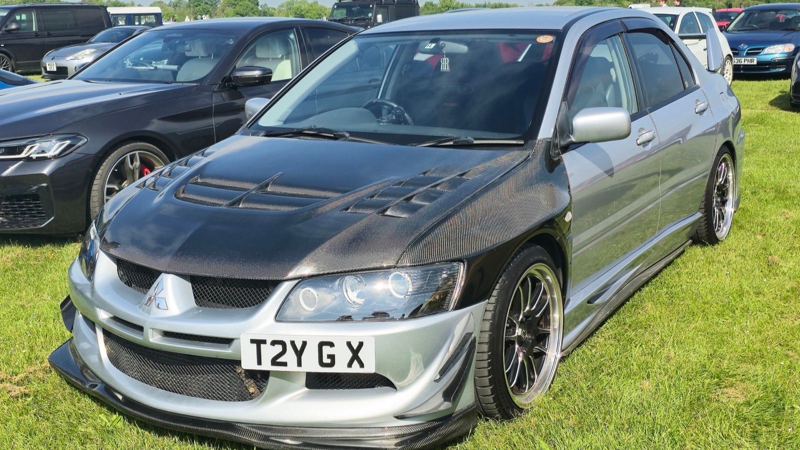 Silver 2004 Mitsubishi Lancer Evolution VIII MR FQ-400 sedan with carbon-fibre bonnet, front three-quarter view