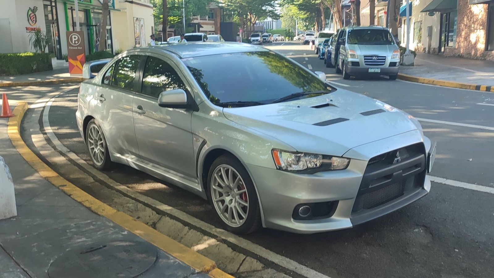 Silver 2008 Mitsubishi Lancer Evolution X sedan parked on a street, front three-quarter view