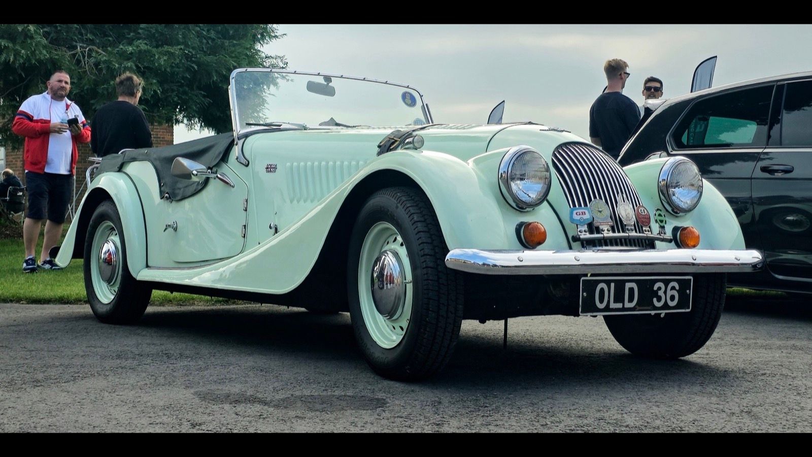 Pale green 1978 Morgan 4/4 roadster with hood folded down, front three-quarter view