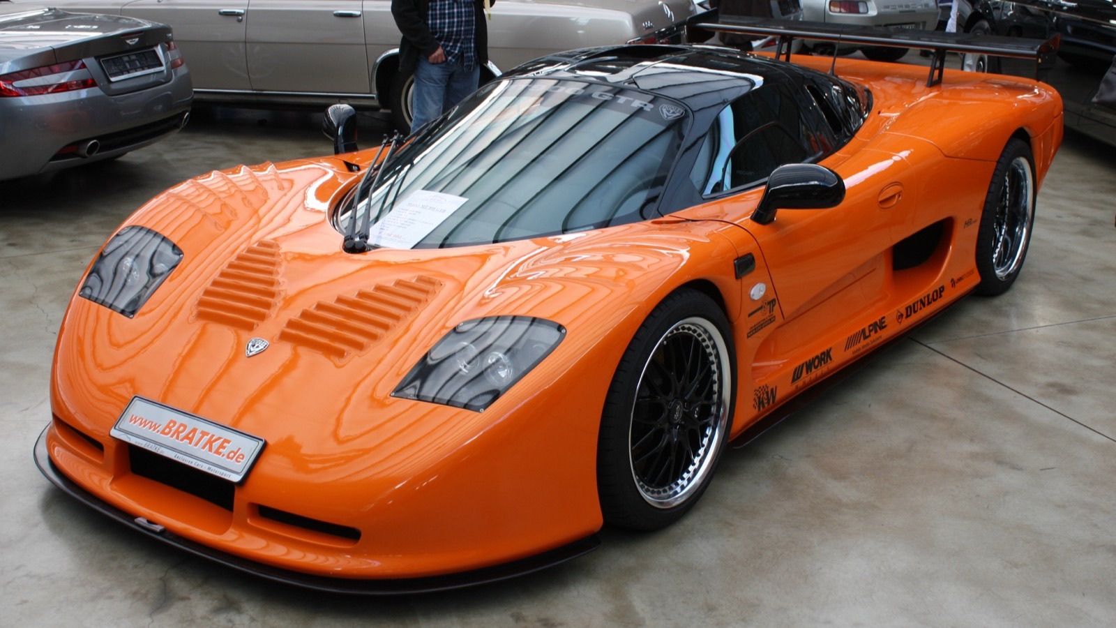 Orange street-legal Mosler MT900 GTR with 7.0-liter V8 and rear wing, front three-quarter view