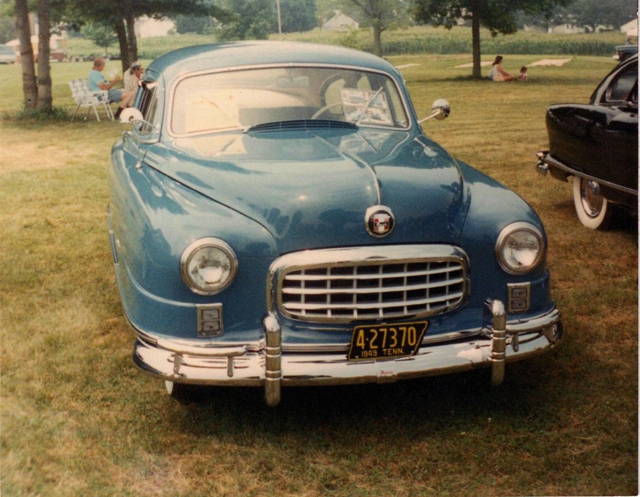 Blue 1949 Nash Ambassador Airflyte sedan, front view on grass at an outdoor car show