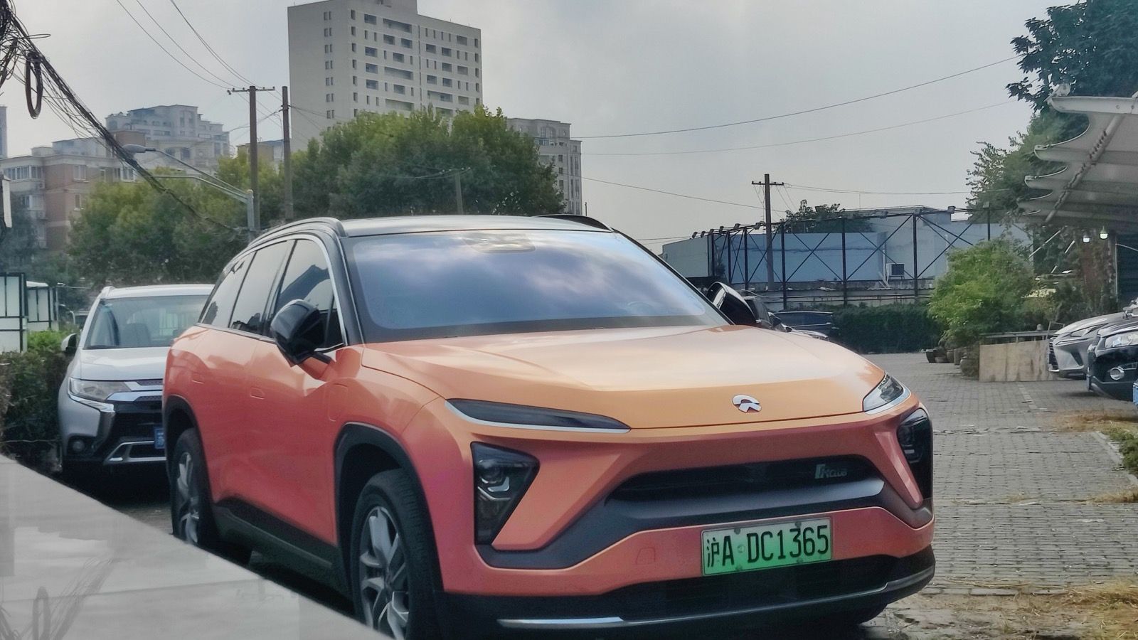 Orange 2022 NIO ES6 parked on a Shanghai street, front three-quarter view