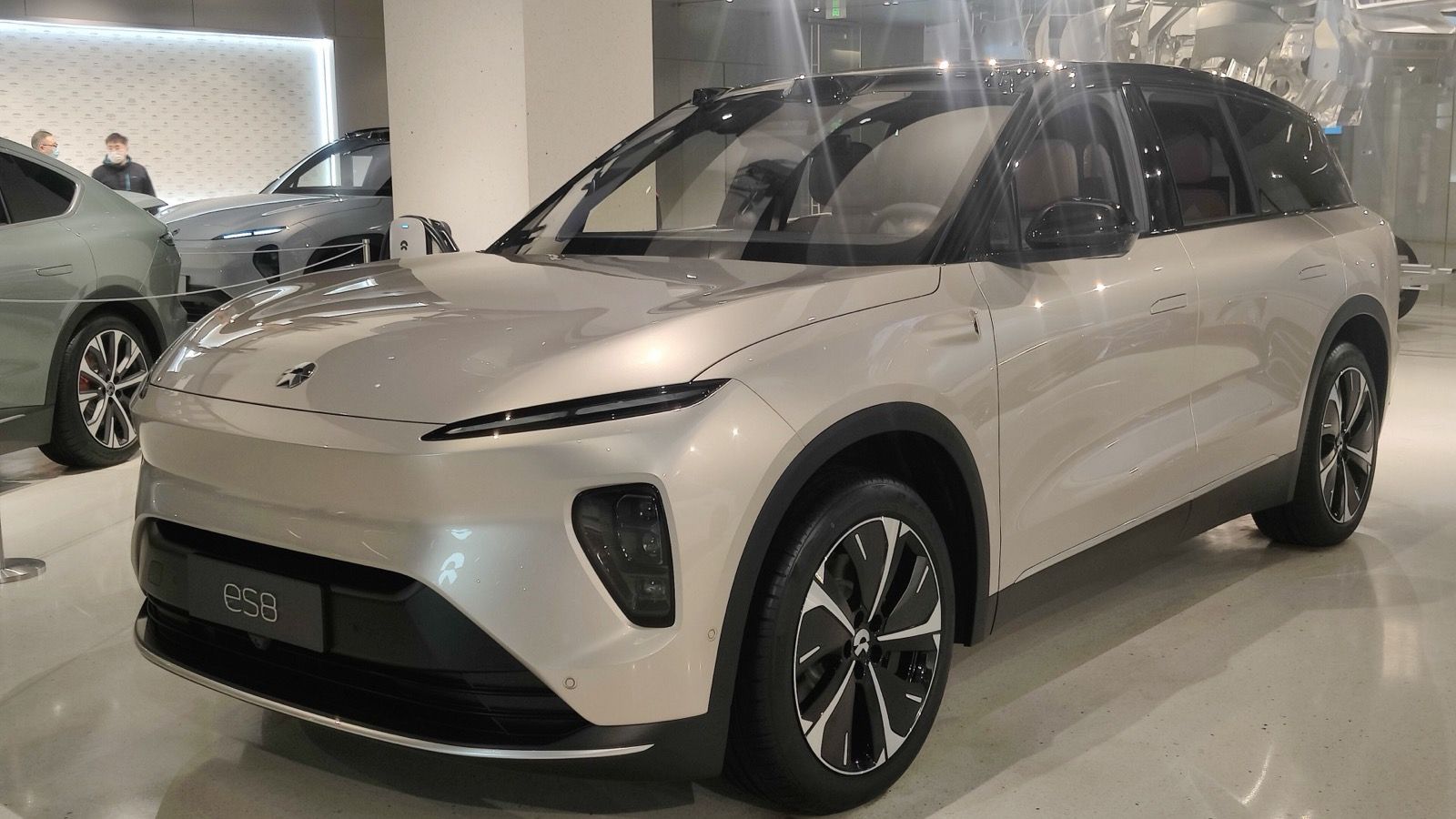 Champagne second-generation NIO ES8 in a showroom, front three-quarter view