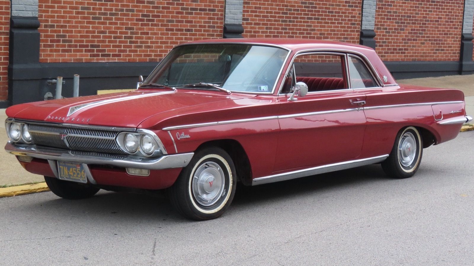 Red 1962 Oldsmobile F-85 Cutlass two-door coupe, front three-quarter view
