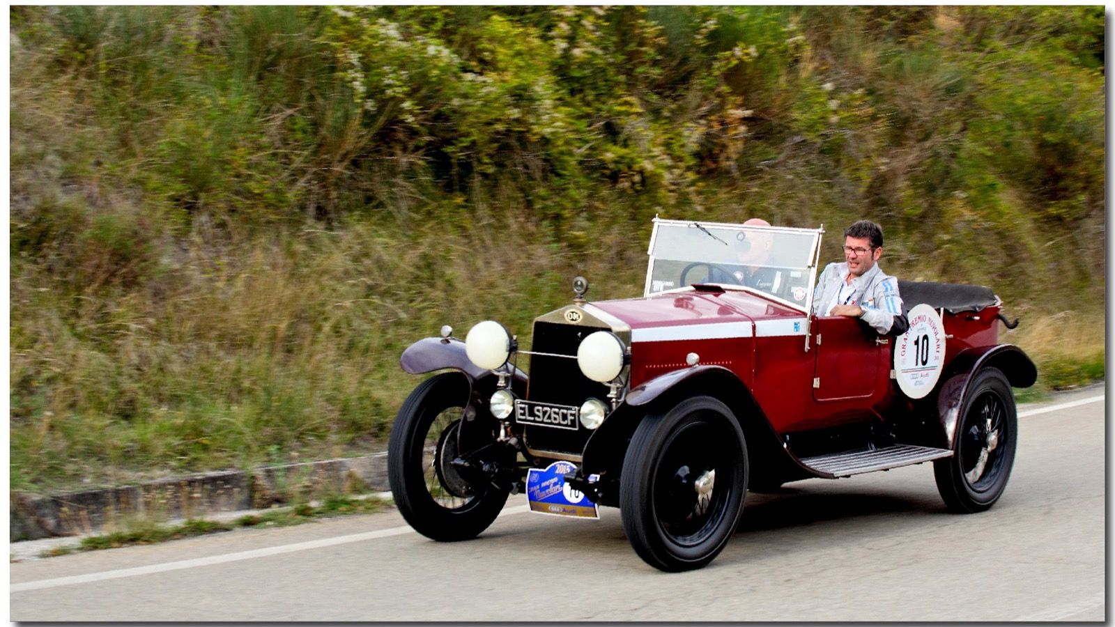 Dark red 1926 OM 665 S MM Superba open tourer on a rally road, front three-quarter view