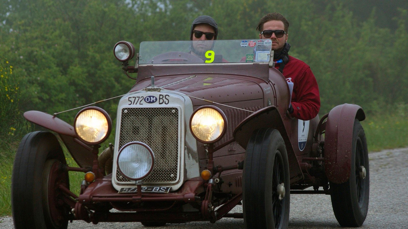 Maroon 1930 OM 665 Superba open sports car on a rally road, front view