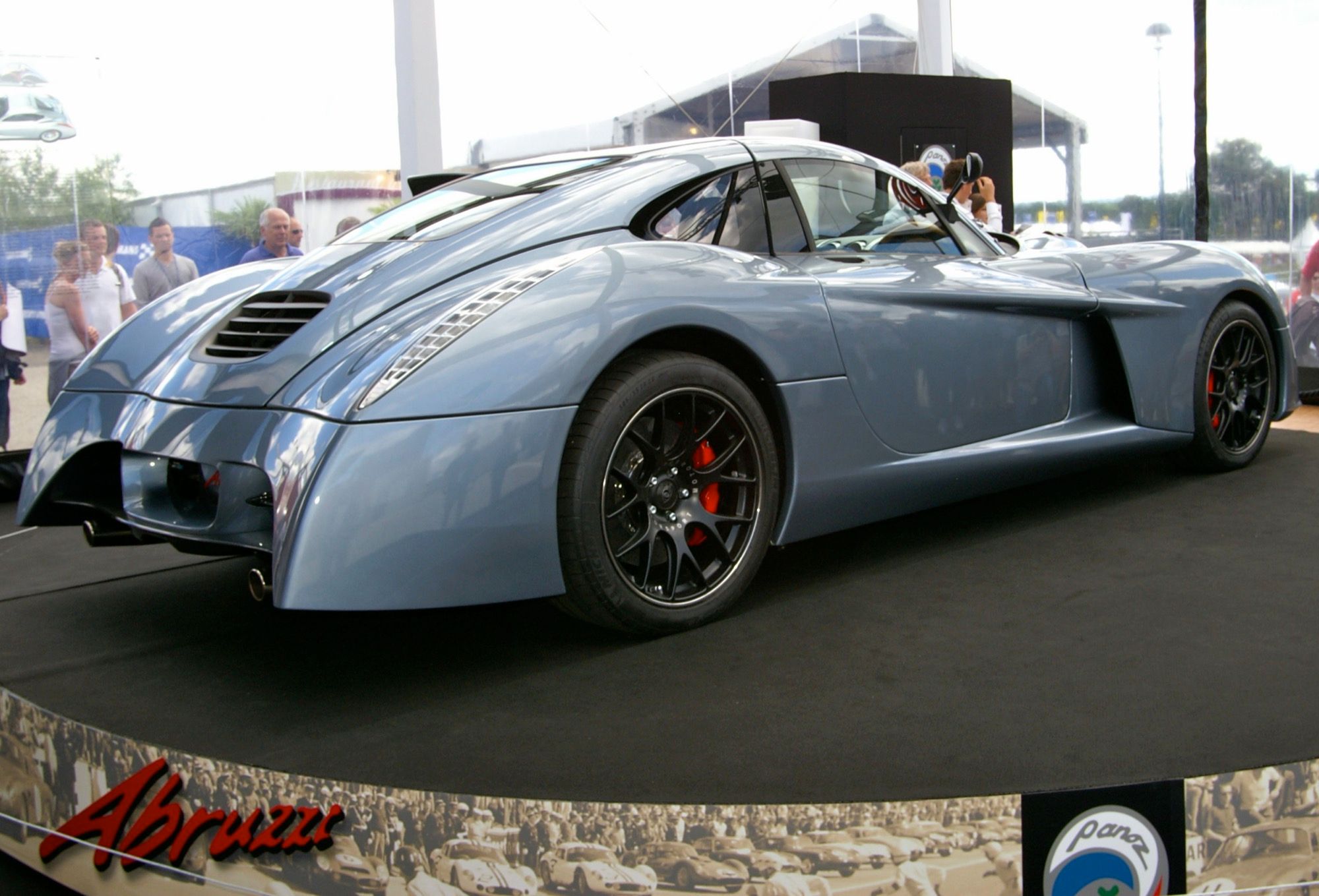Blue-grey Panoz Abruzzi 'Spirit of Le Mans' on display, rear three-quarter view