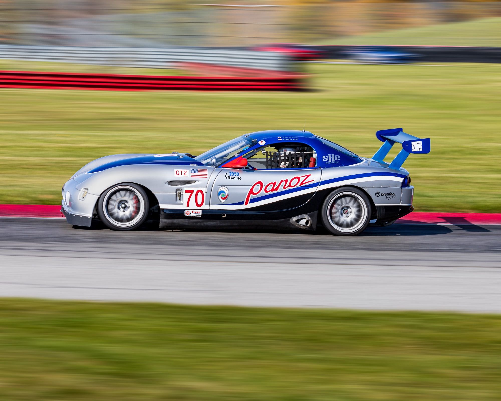 Silver and blue 2005 Panoz Esperante GTS race car, side profile on track