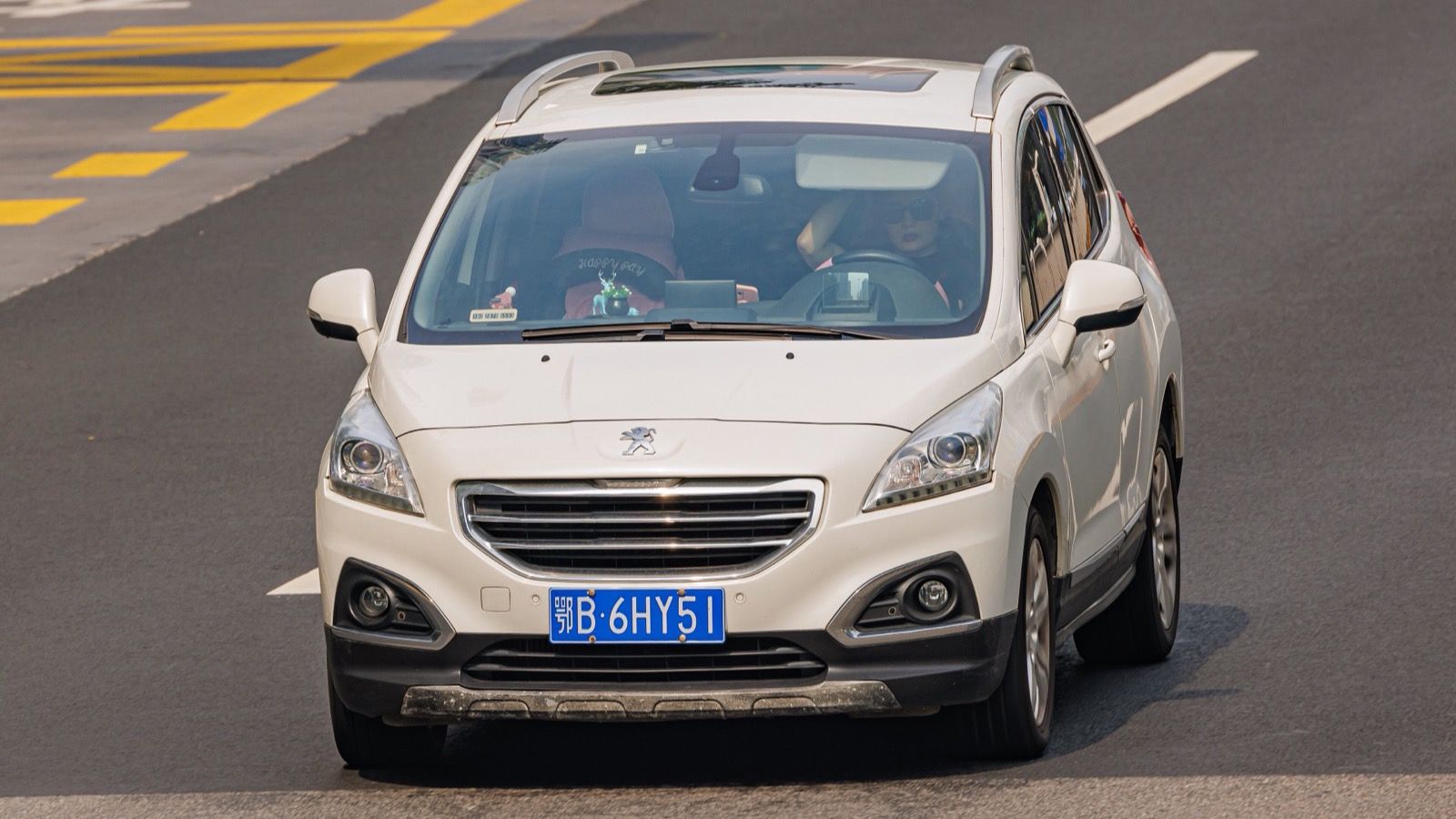 White first-generation Peugeot 3008 crossover on a road in China, front view