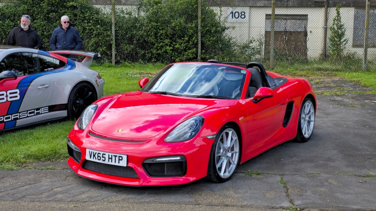 Red 2015 Porsche Boxster Spyder (981) with roof down, front three-quarter view