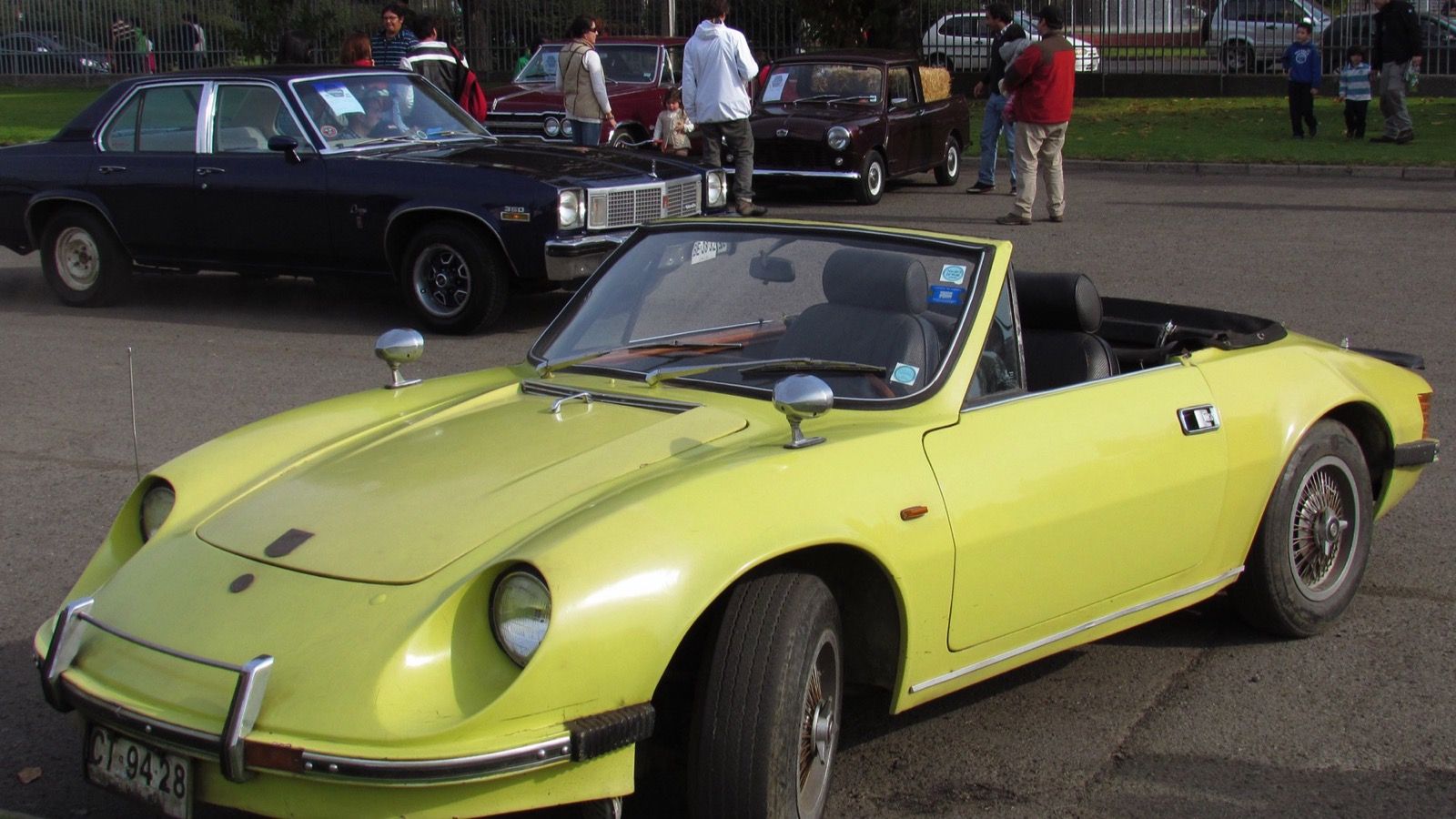 Yellow 1980 Puma GTS roadster with wire wheels and the top down, front three-quarter view at a classic car meeting in Chile