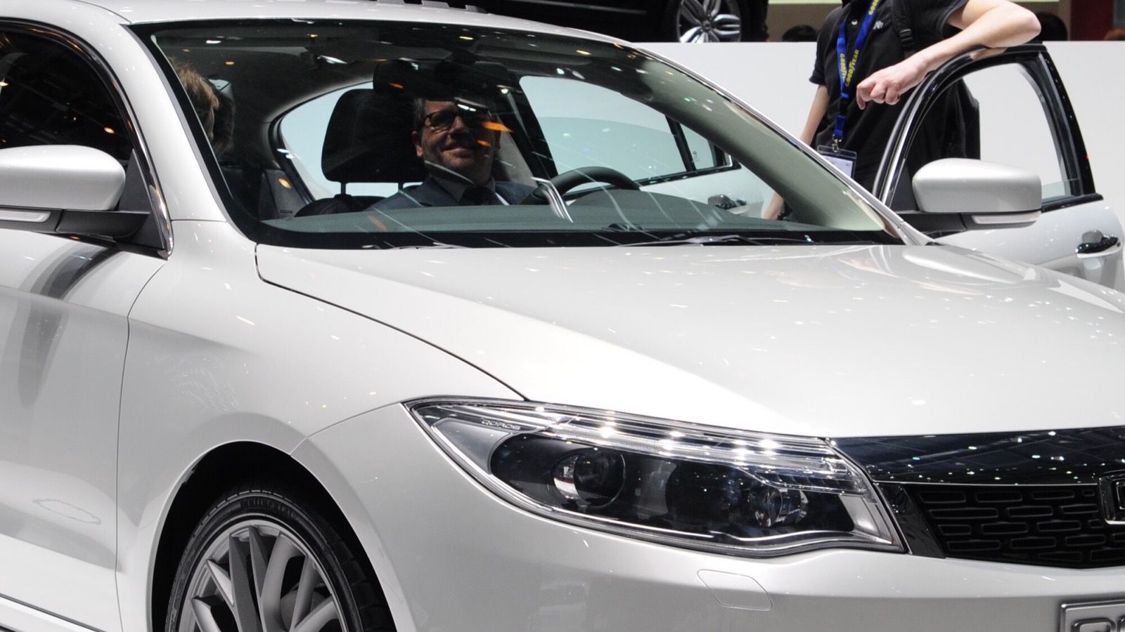 White Qoros 3 sedan on the Qoros stand at the 2013 Geneva Motor Show, front three-quarter view