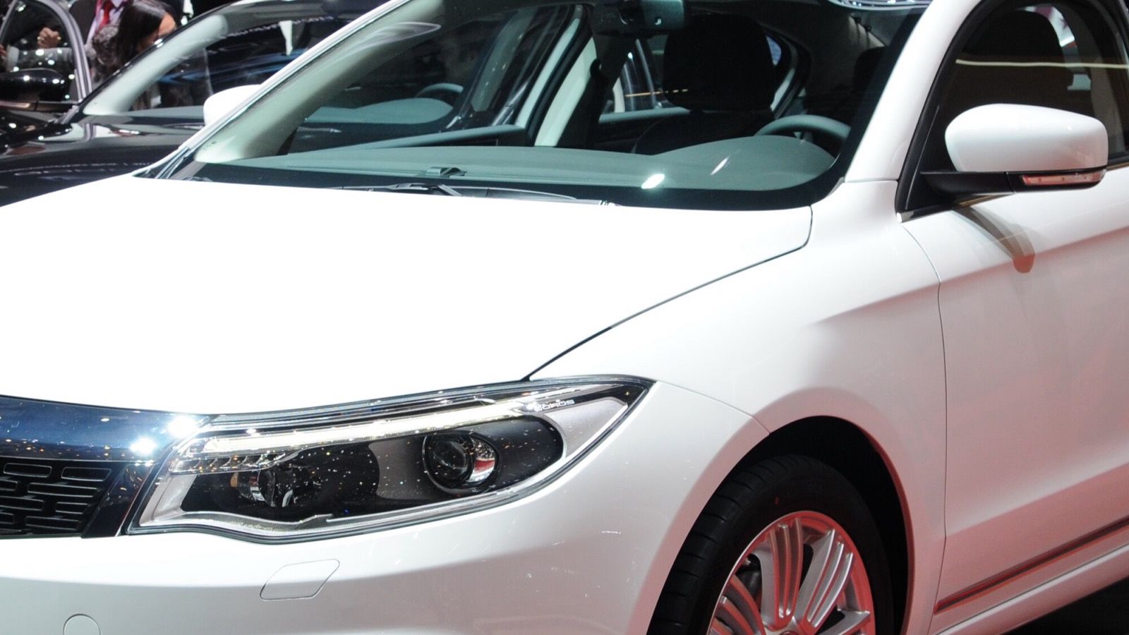 White Qoros 3 sedan displayed at the 2014 Geneva Motor Show, front three-quarter view
