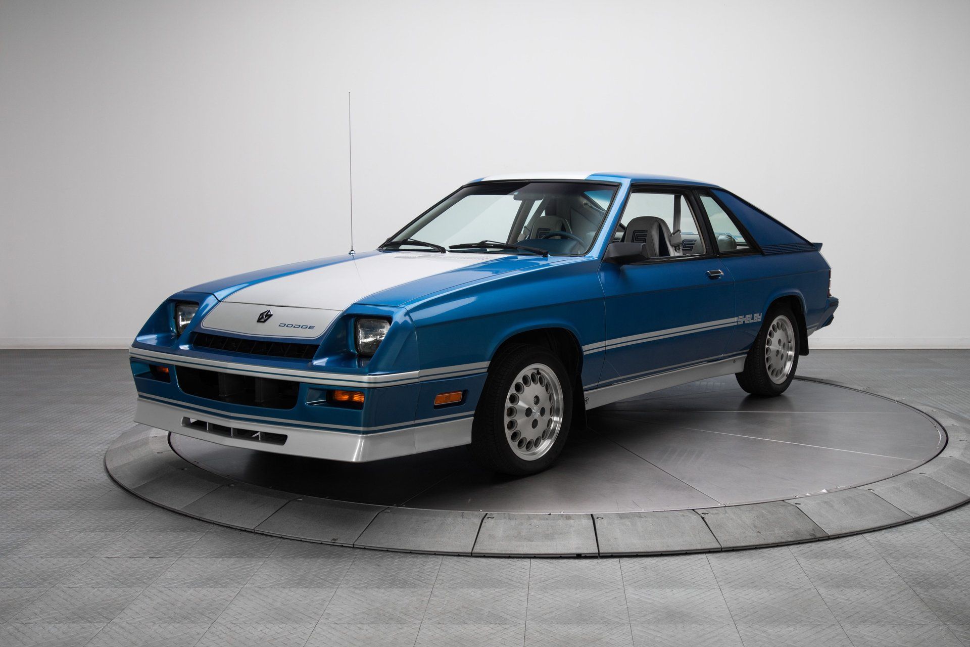 1983 Dodge Charger, blue and silver hatchback with Shelby graphics, front three-quarter view