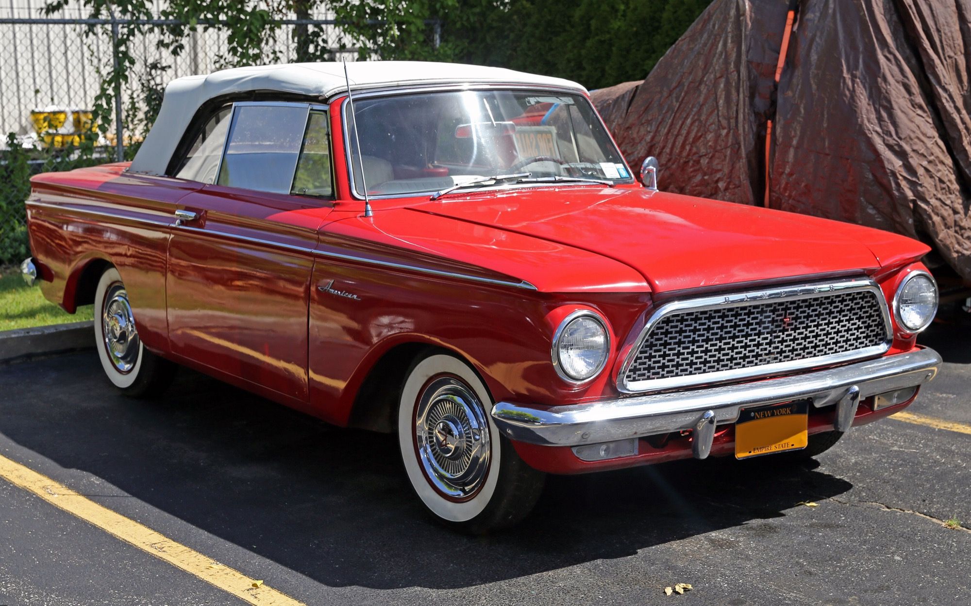 Red 1961 Rambler American convertible with white top raised, front three-quarter view