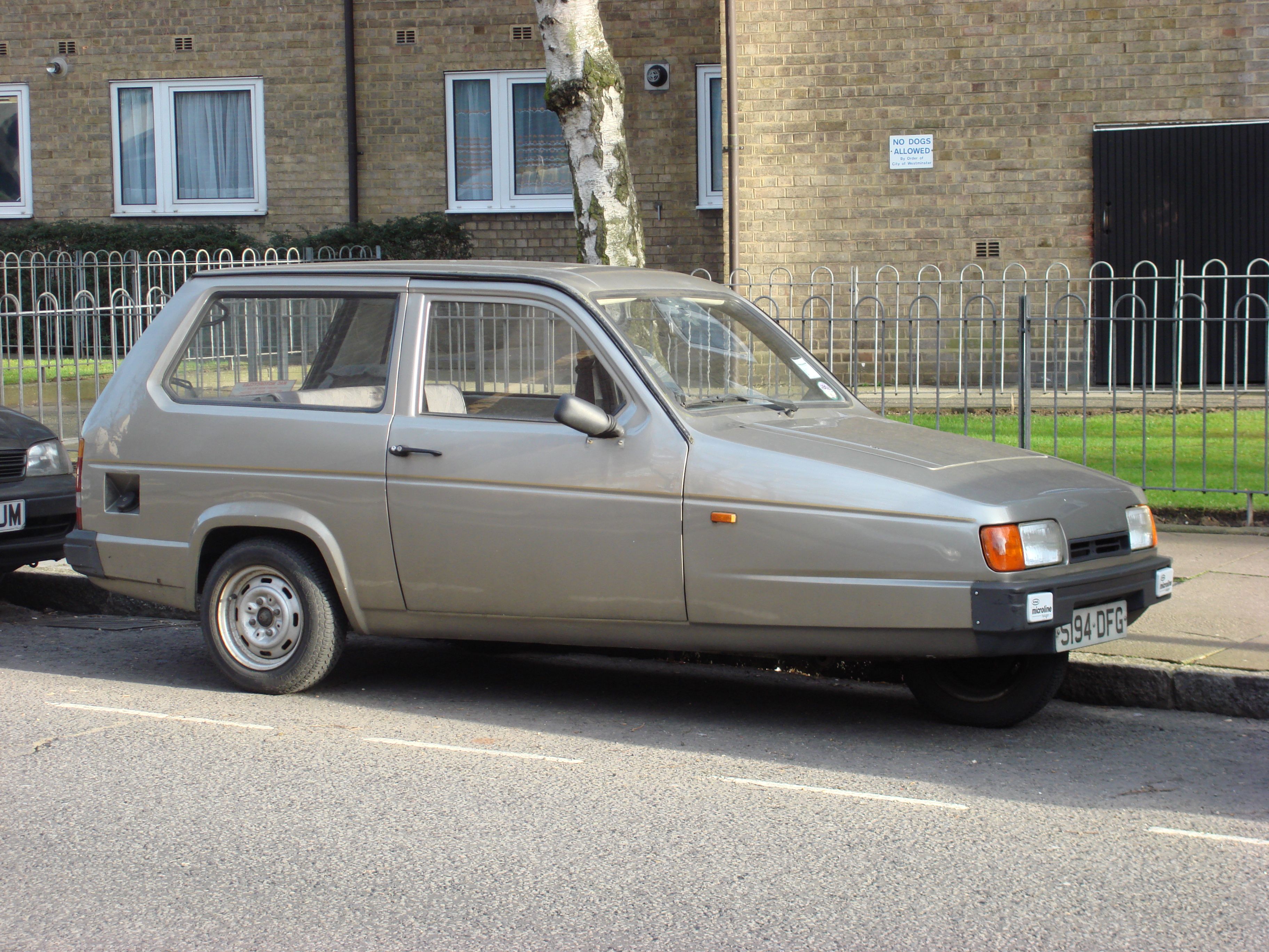 Grey 1989 Reliant Robin saloon parked at the kerb, side profile