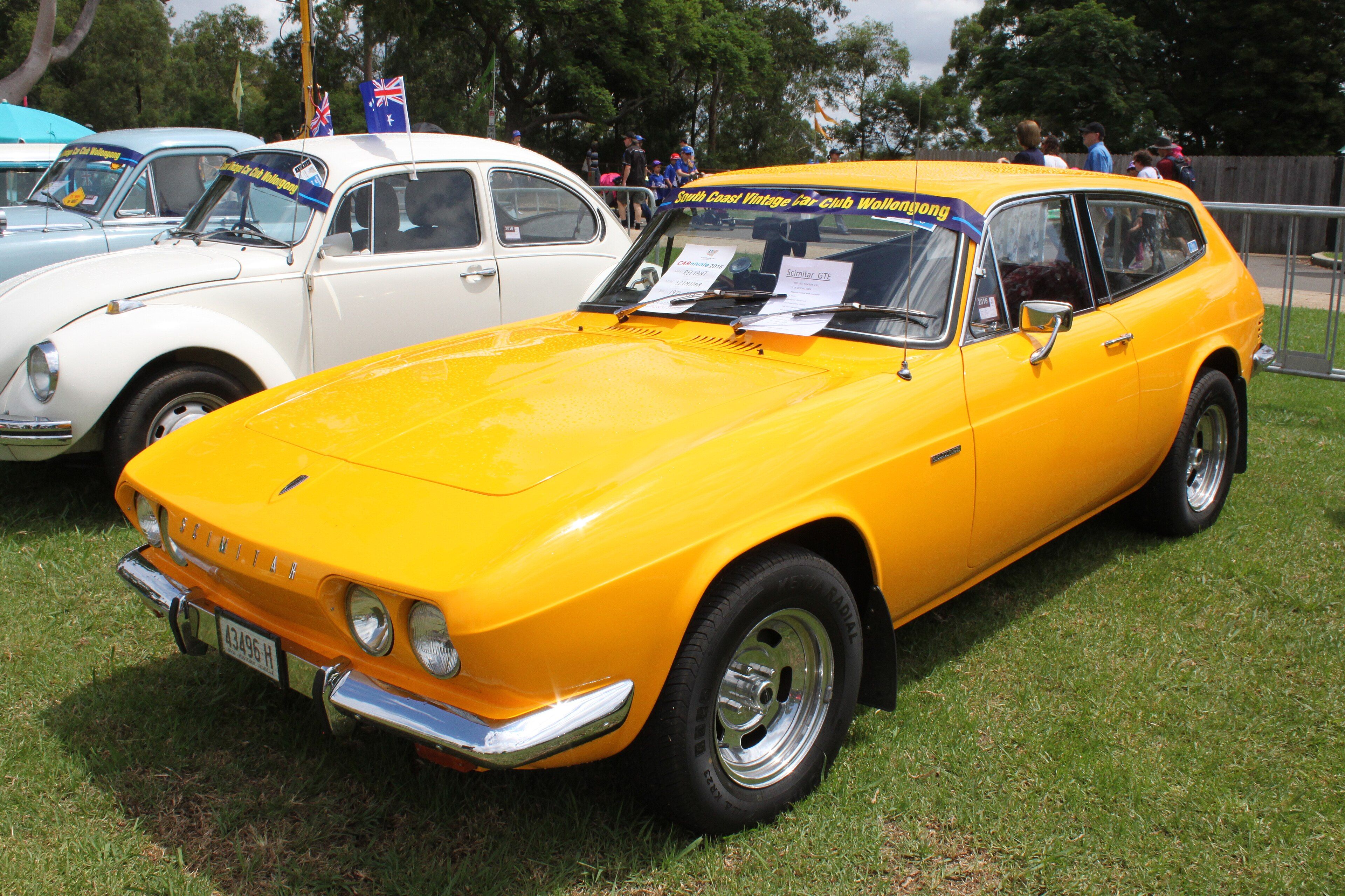 Orange 1971 Reliant Scimitar GTE sporting estate on grass, front three-quarter view