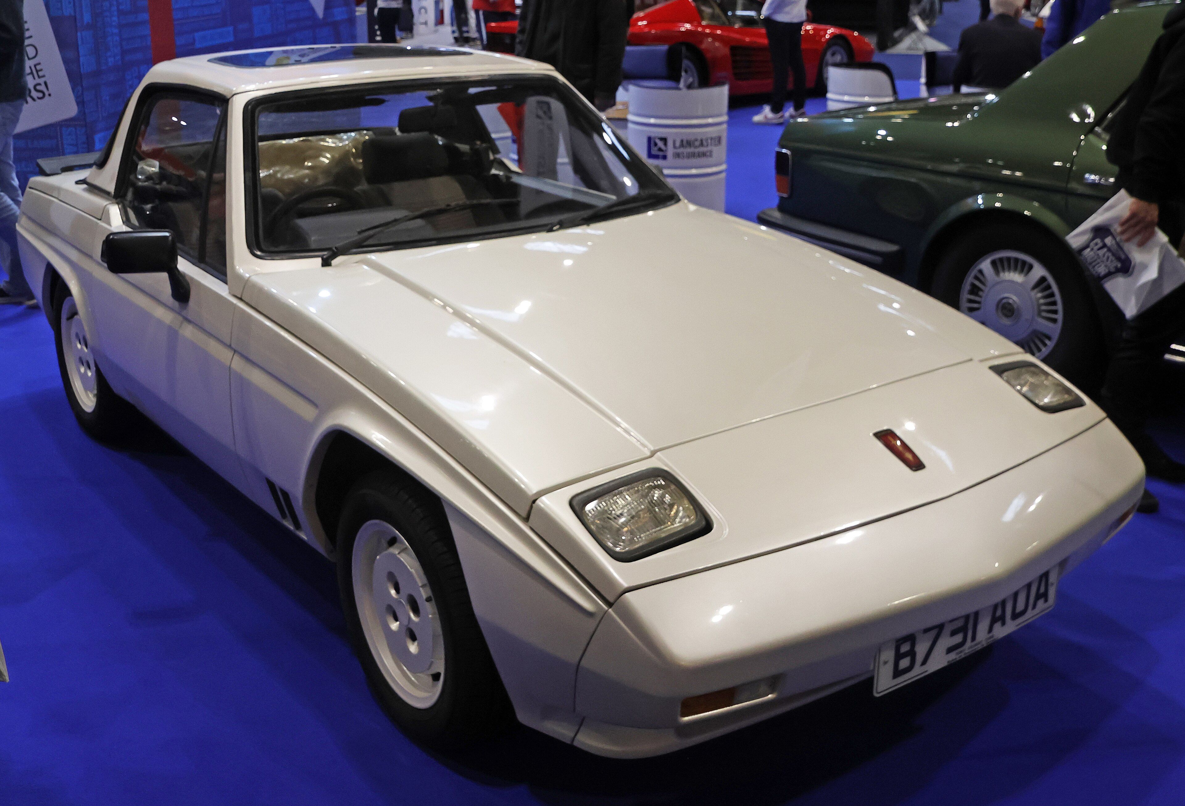 White 1984 Reliant Scimitar SS1 roadster with hardtop on show display, front three-quarter view