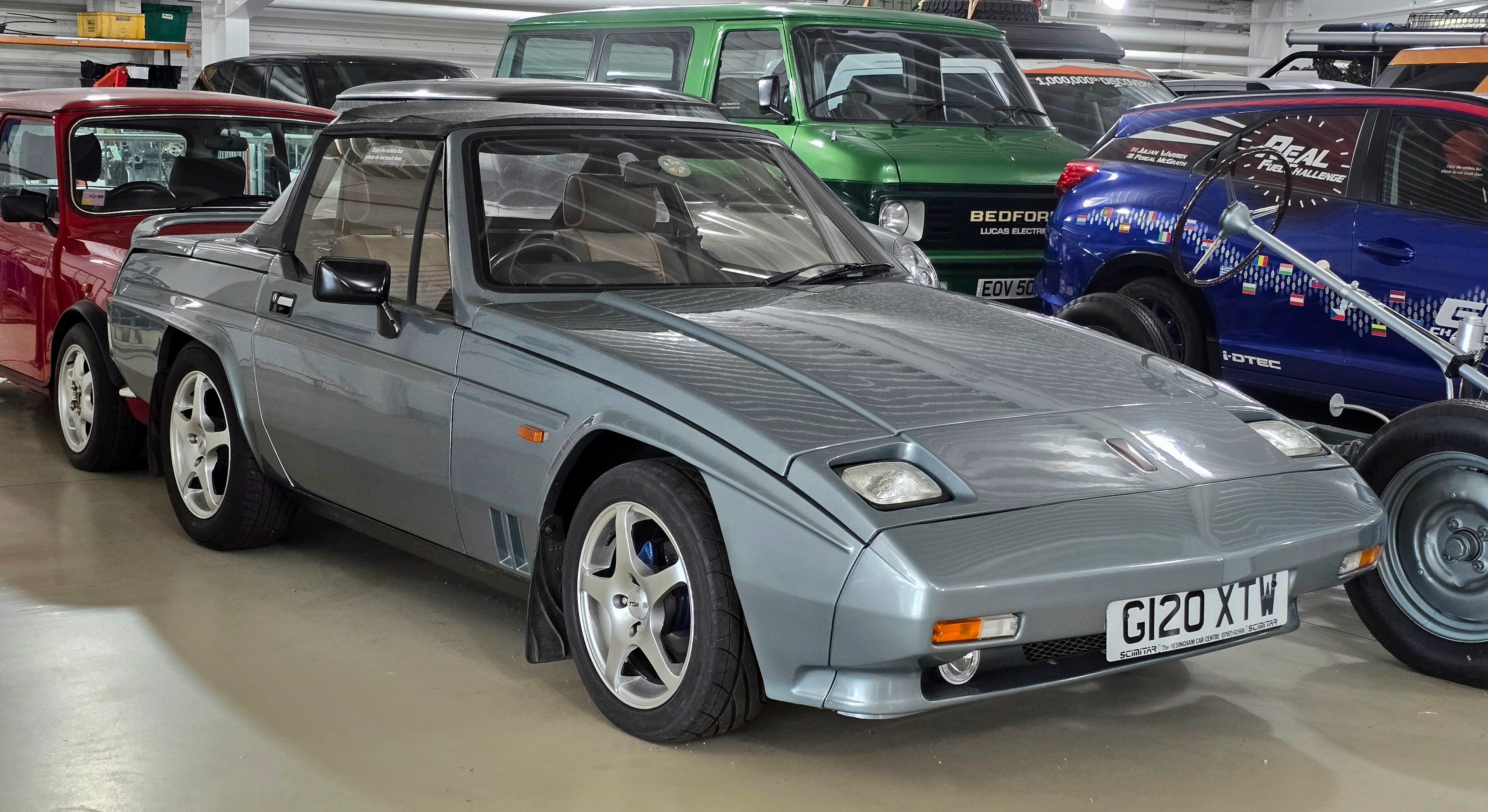 Silver 1989 Reliant Scimitar SS1 on indoor display, front three-quarter view