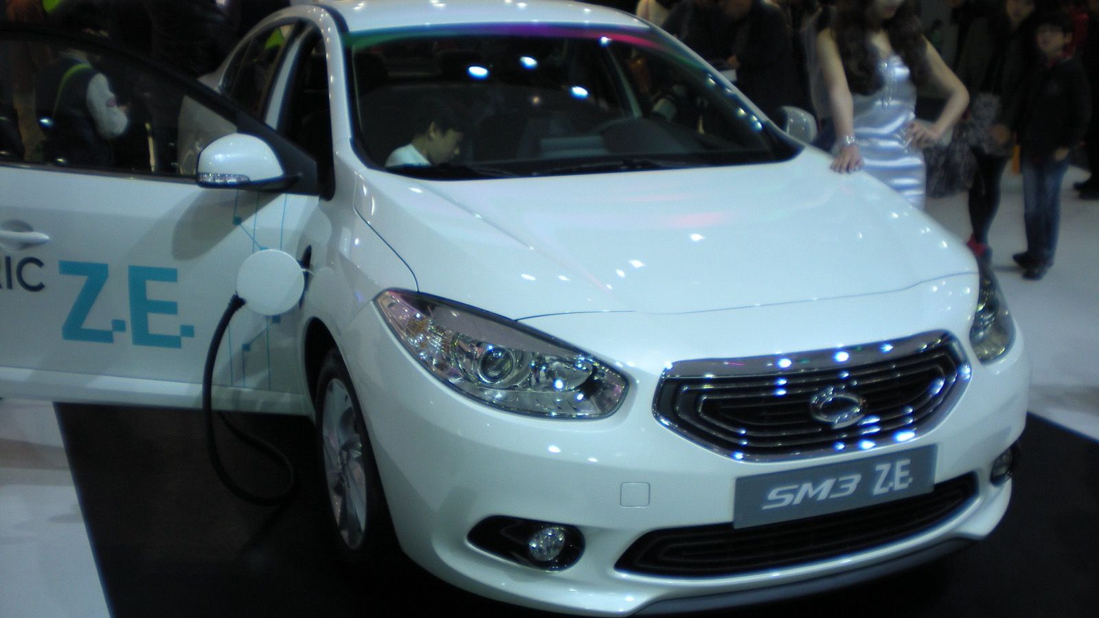 White 2013 Renault Samsung SM3 Z.E. on show stand, front three-quarter view
