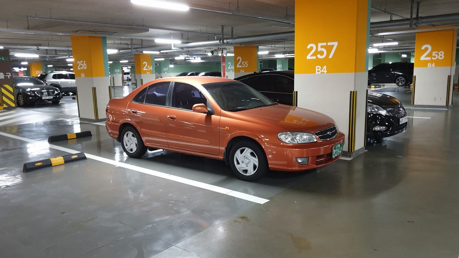 Orange first-generation Renault Samsung SM3, front three-quarter view