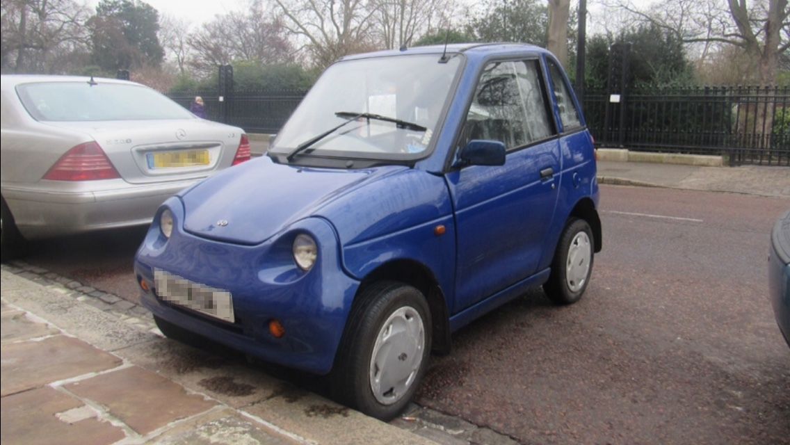 Blue 2008 REVAi G-Wiz parked in London, front three-quarter view