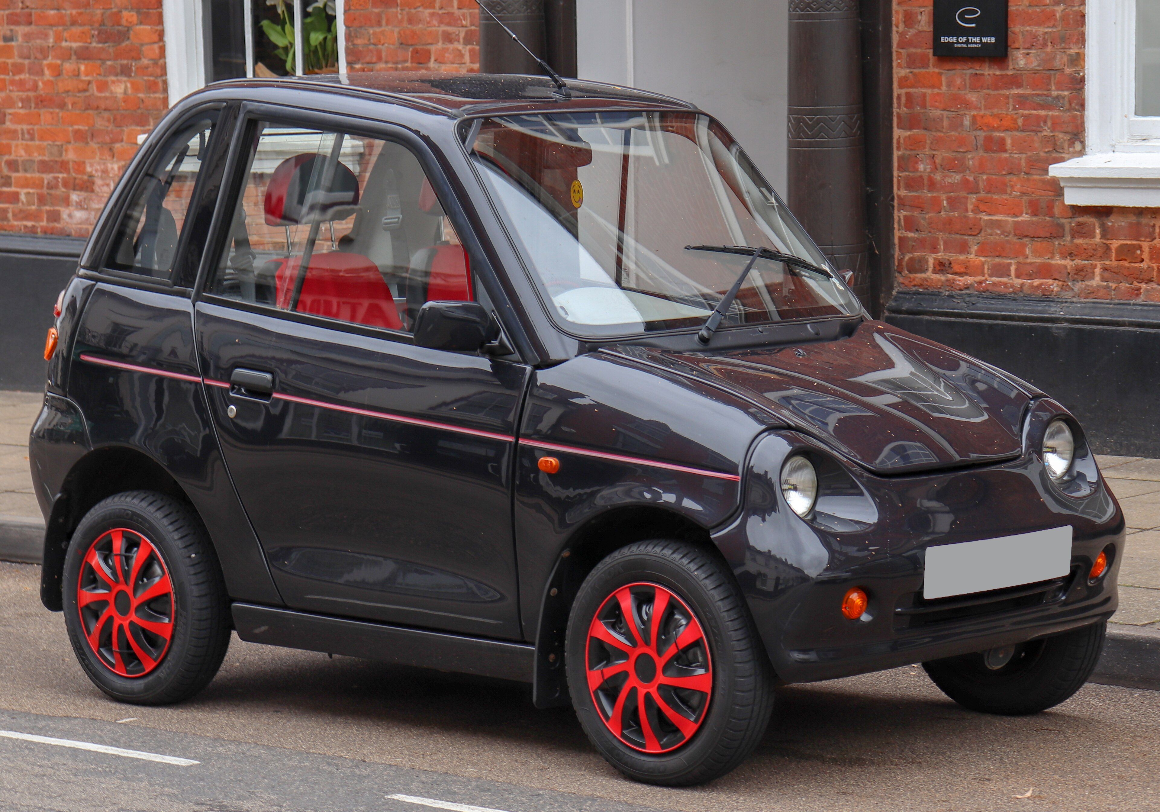 Black 2009 REVAi G-Wiz with red wheel trims, front three-quarter view