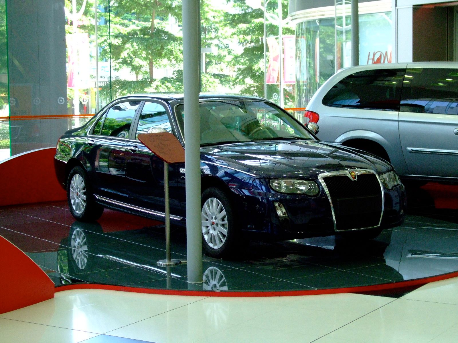 Dark blue Roewe 750 V6 sedan on a showroom display floor, front three-quarter view