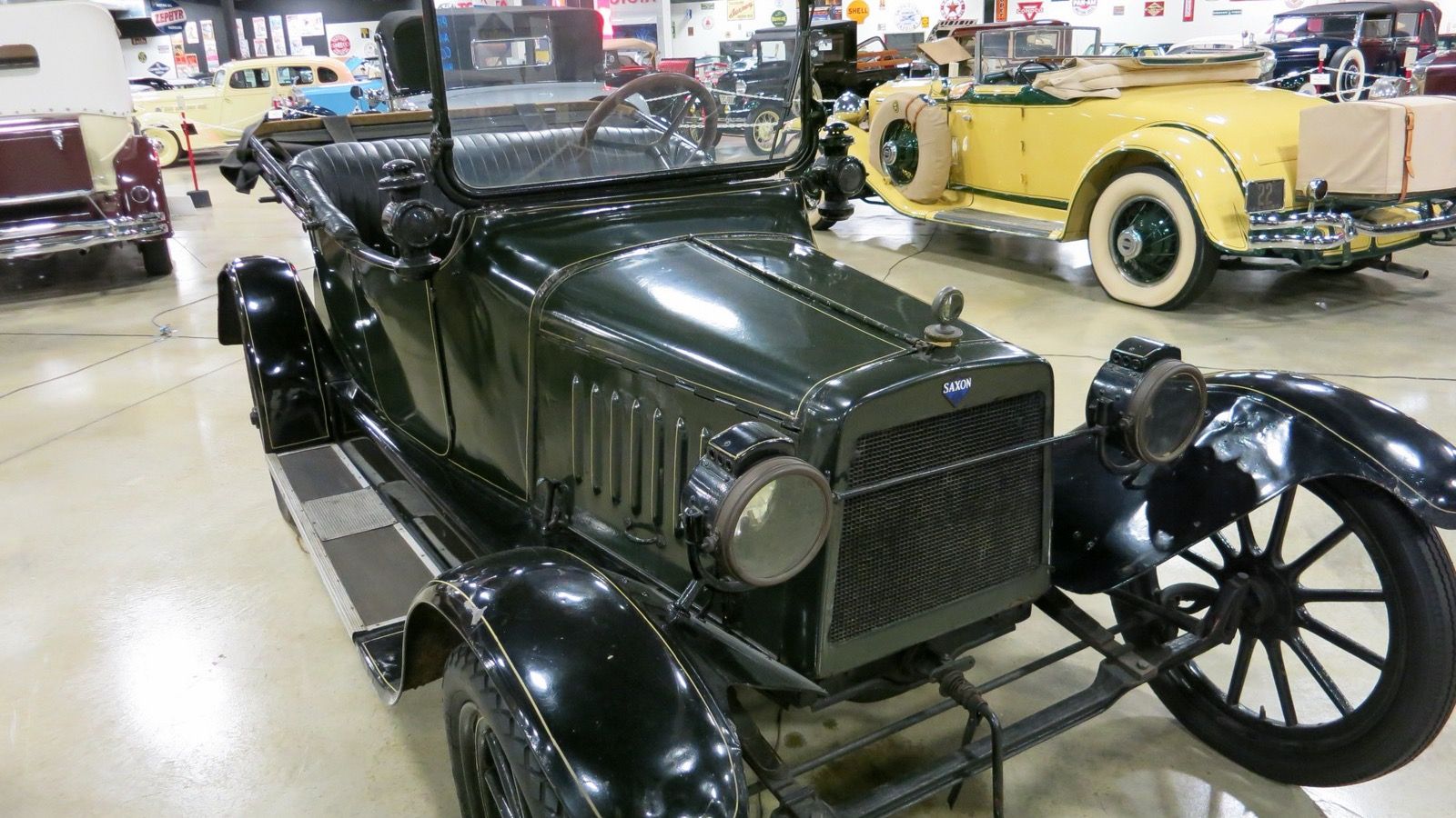 Dark green 1914 Saxon four-cylinder roadster, front three-quarter view, on museum display