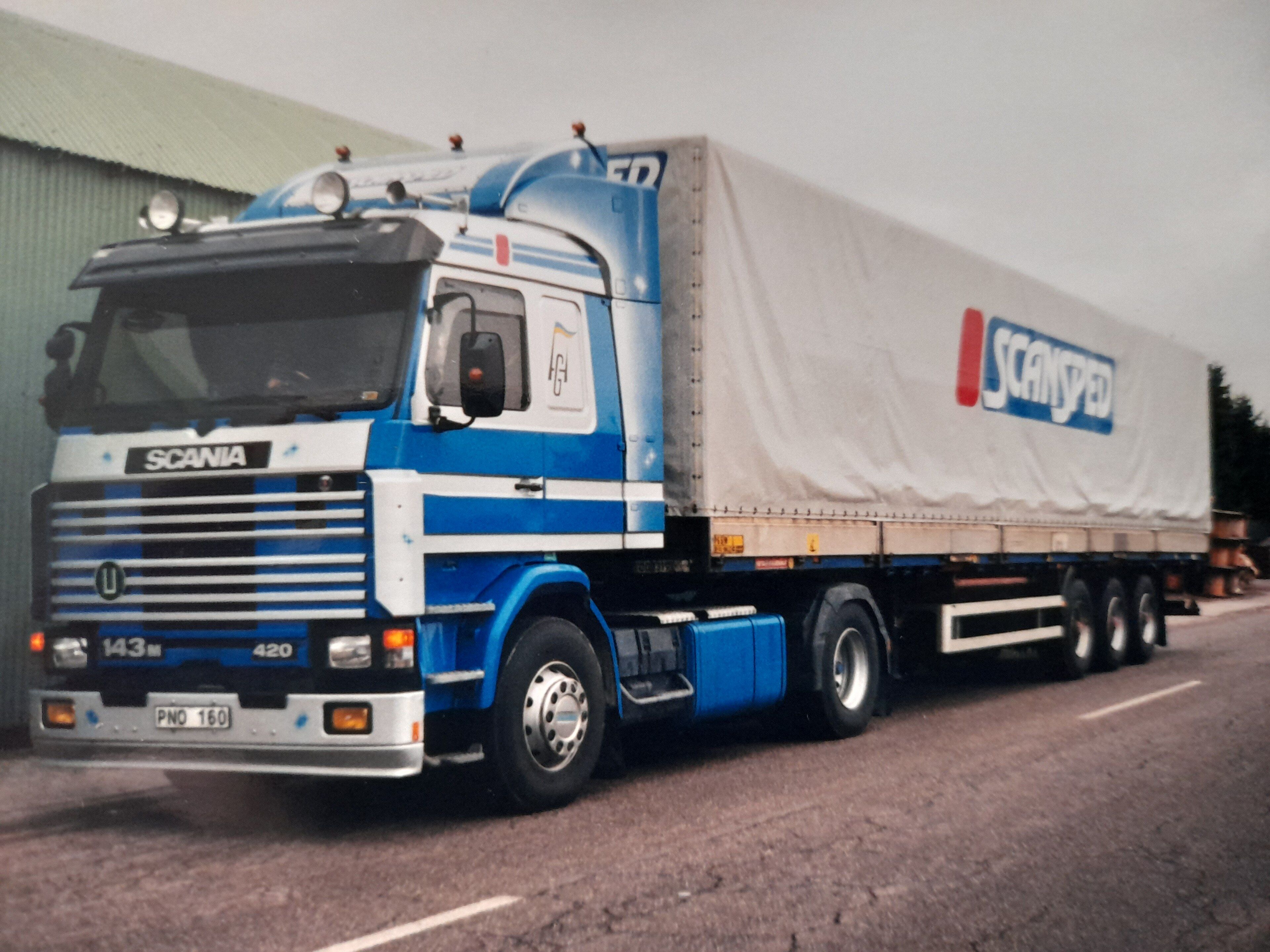 Blue and white 1994 Scania 143M 420 Streamline tractor with curtain-side trailer, front three-quarter view