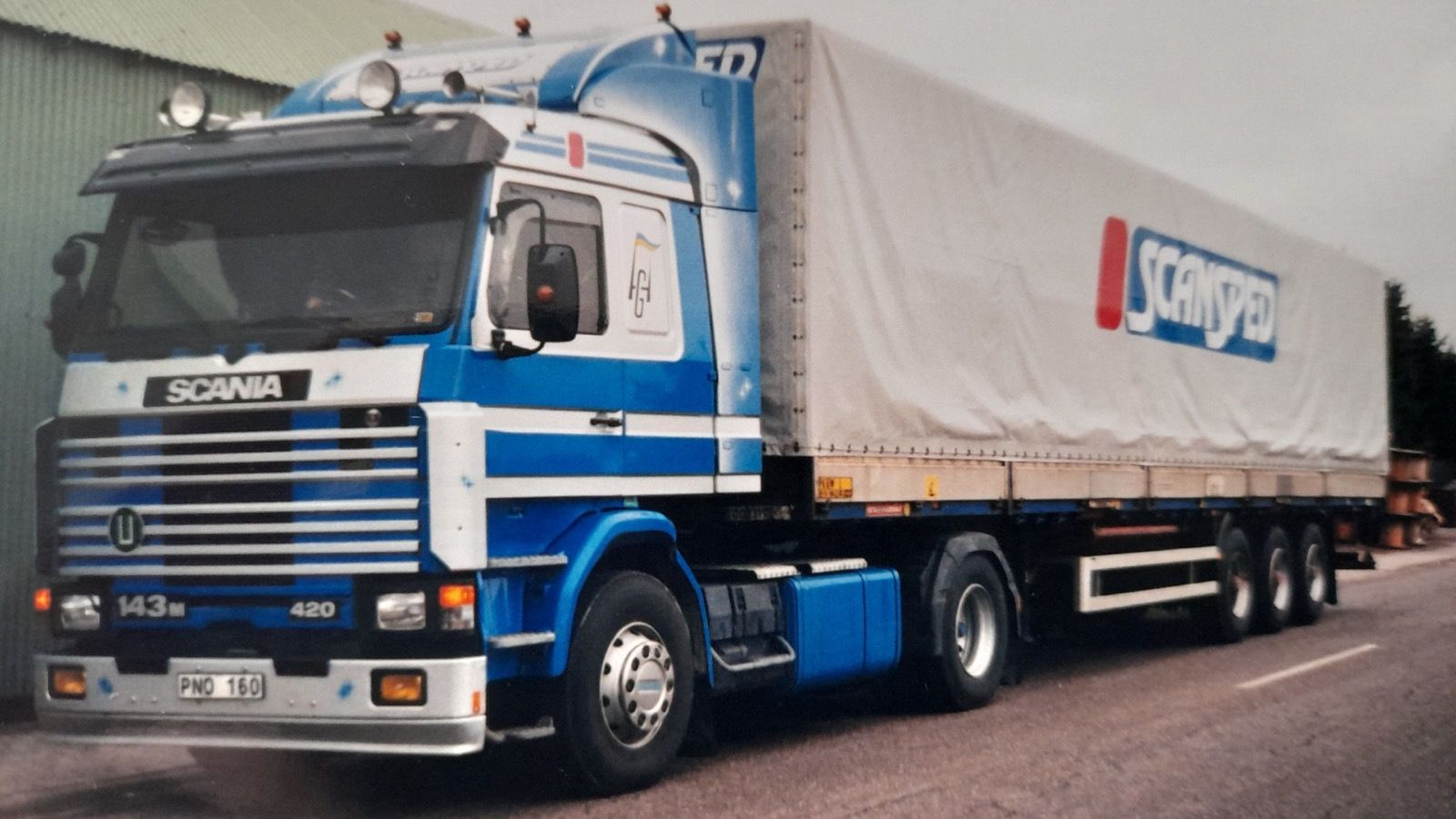 Blue and white 1994 Scania 143M 420 Streamline tractor unit, front three-quarter view
