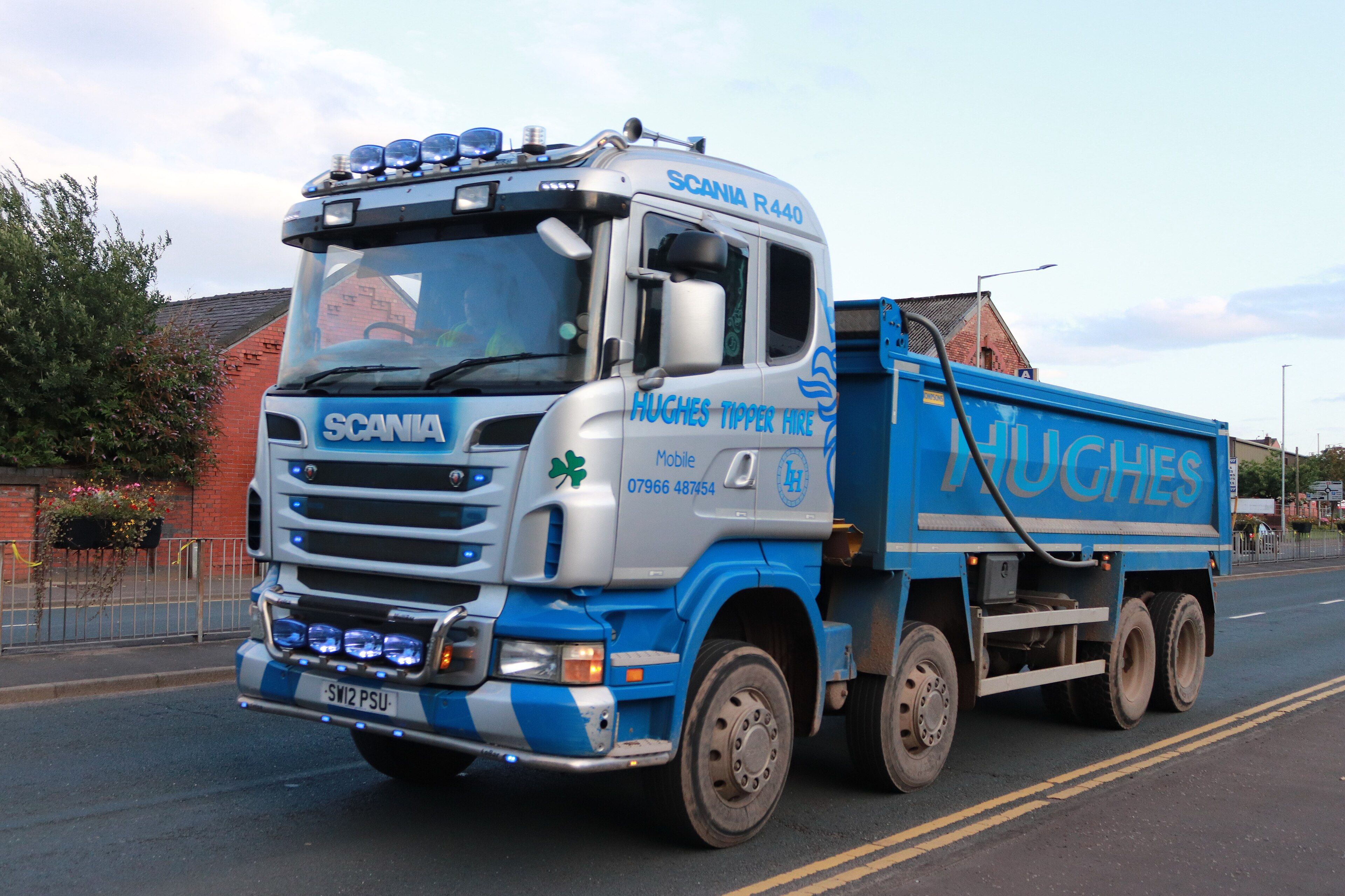 Silver and blue 2012 Scania R440 8x4 tipper truck, front three-quarter view