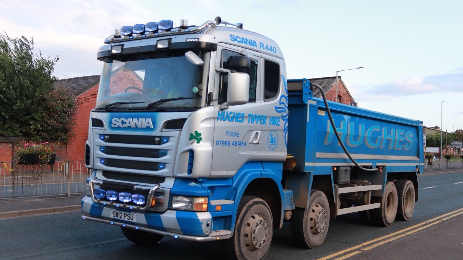 Silver and blue first-generation Scania R440 8x4 tipper, front three-quarter view