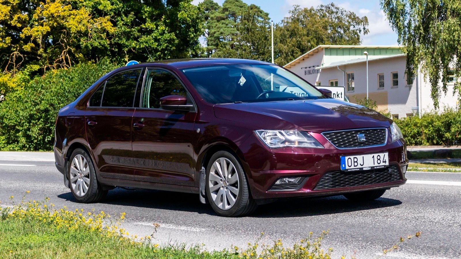 Dark red 2013 SEAT Toledo Mk4 (NH) liftback saloon, front three-quarter view