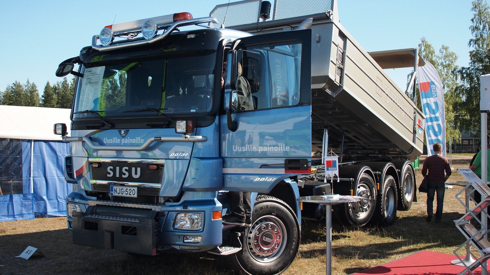 Blue Sisu Polar Works 8x4 tipper truck with raised dump body, front three-quarter view