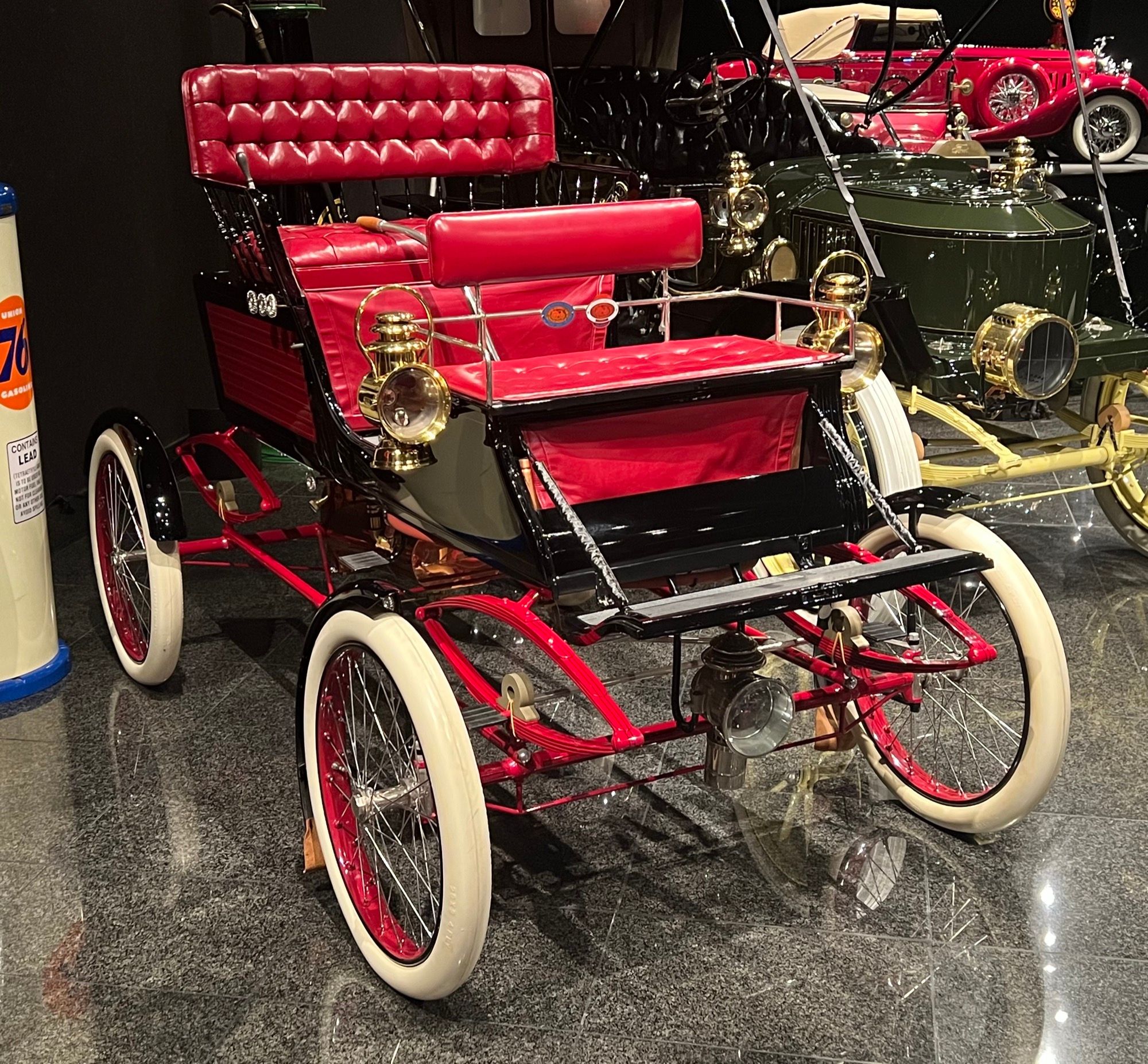 Black and red 1902 Stanley Steamer runabout on museum display, front three-quarter view