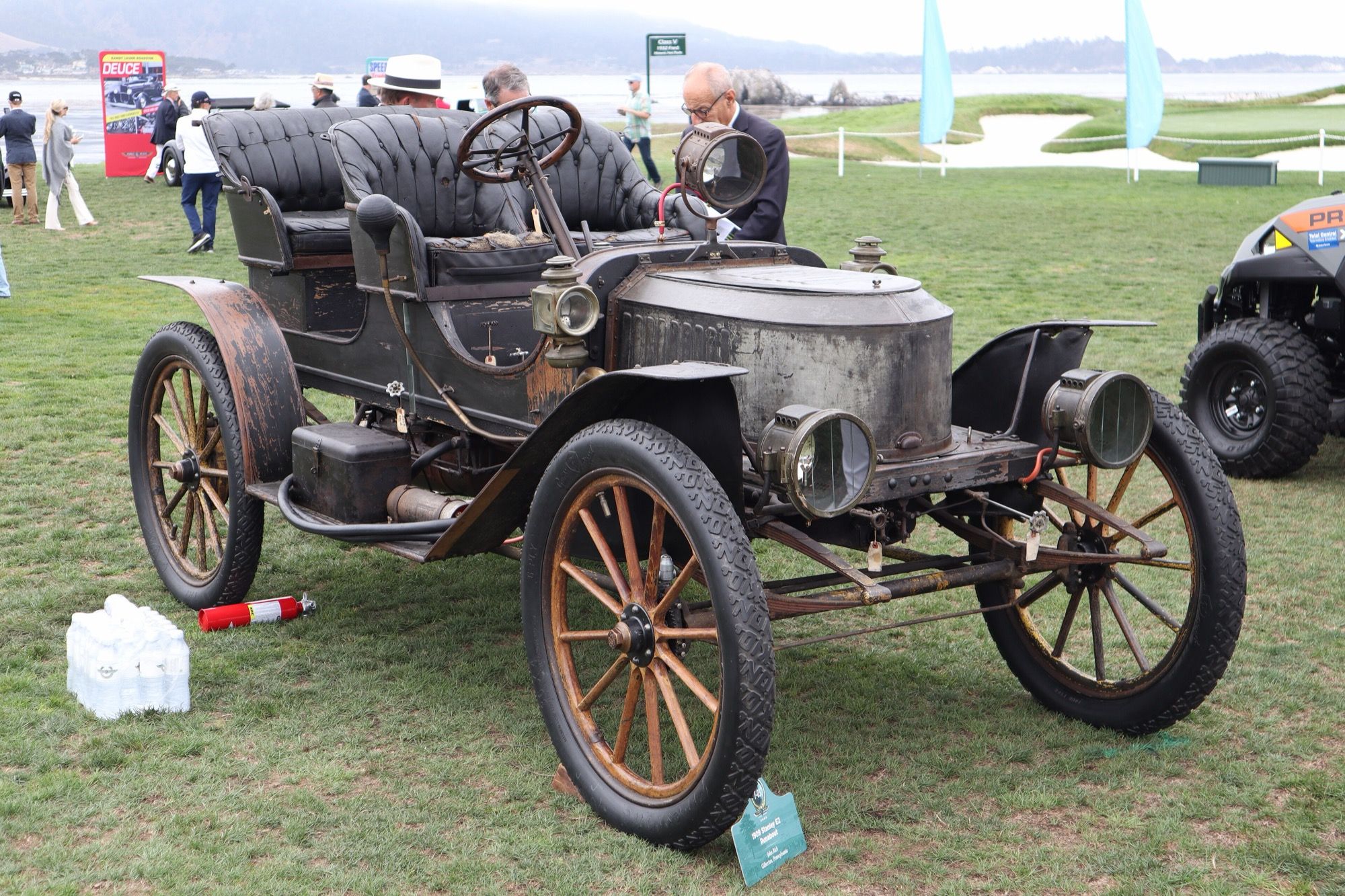 Unrestored 1909 Stanley E2 coffin-nose runabout at Pebble Beach, front three-quarter view