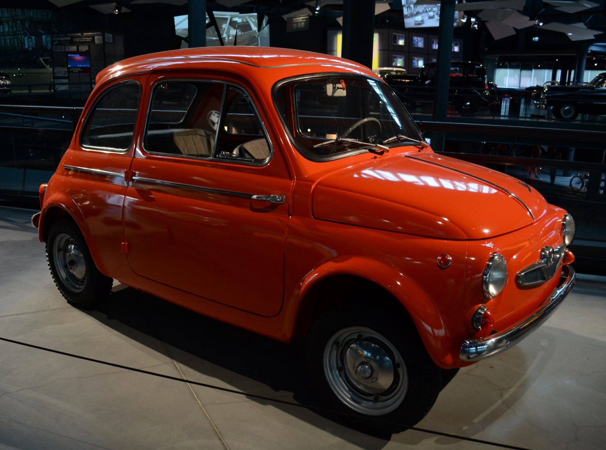 Orange Steyr-Puch 500 D two-door city car on museum display, front three-quarter view