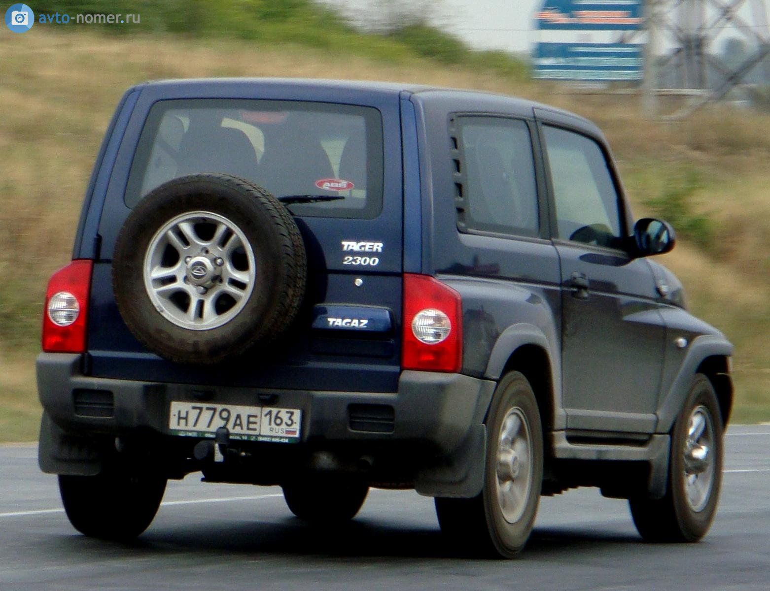 Dark blue 2009 TagAZ Tager three-door SUV with rear-mounted spare wheel, rear three-quarter view