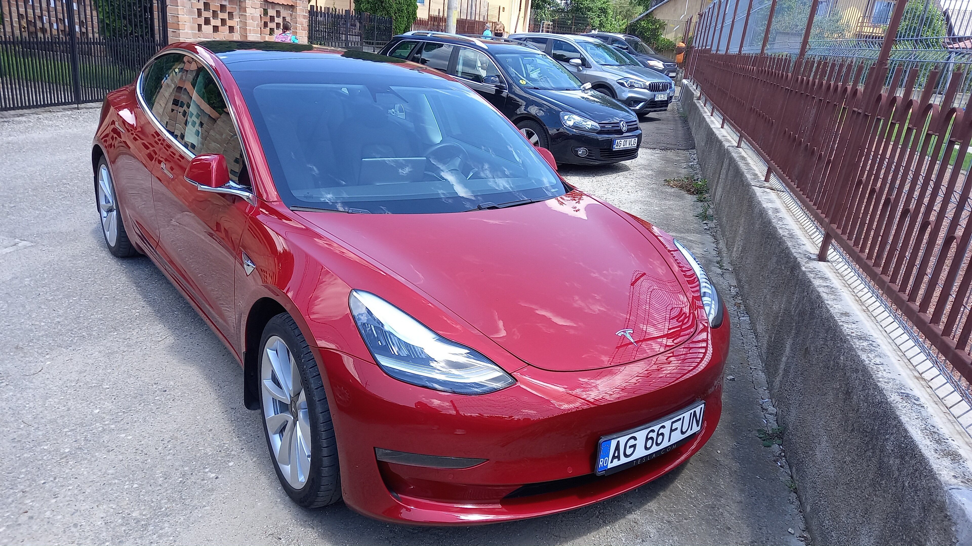 Red 2021 Tesla Model 3, front three-quarter view
