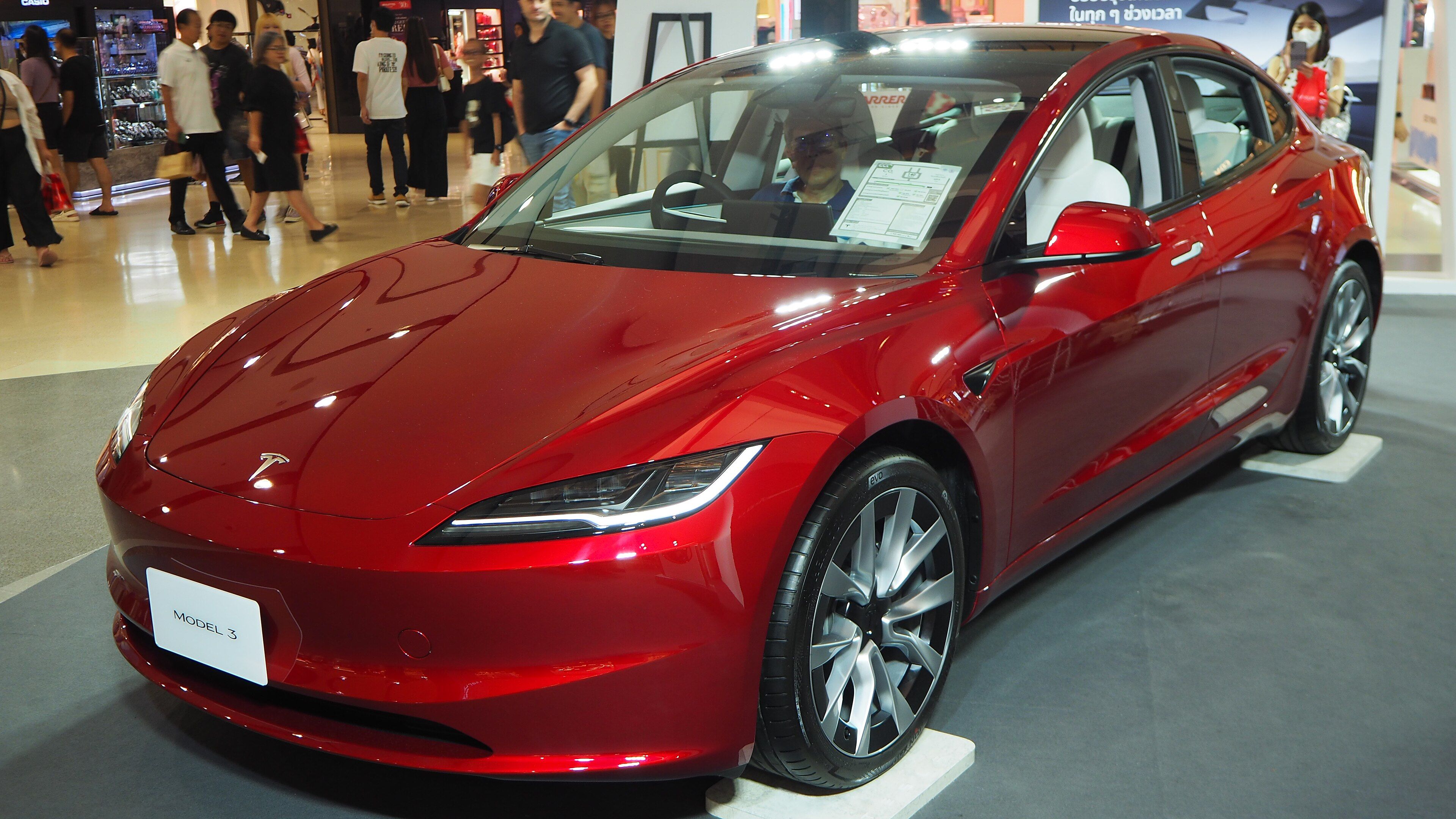 Red 2023 Tesla Model 3 'Highland' refresh, front three-quarter view