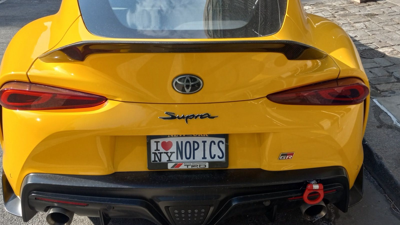 Yellow Toyota GR Supra photographed in New York City in March 2025 — rear detail view