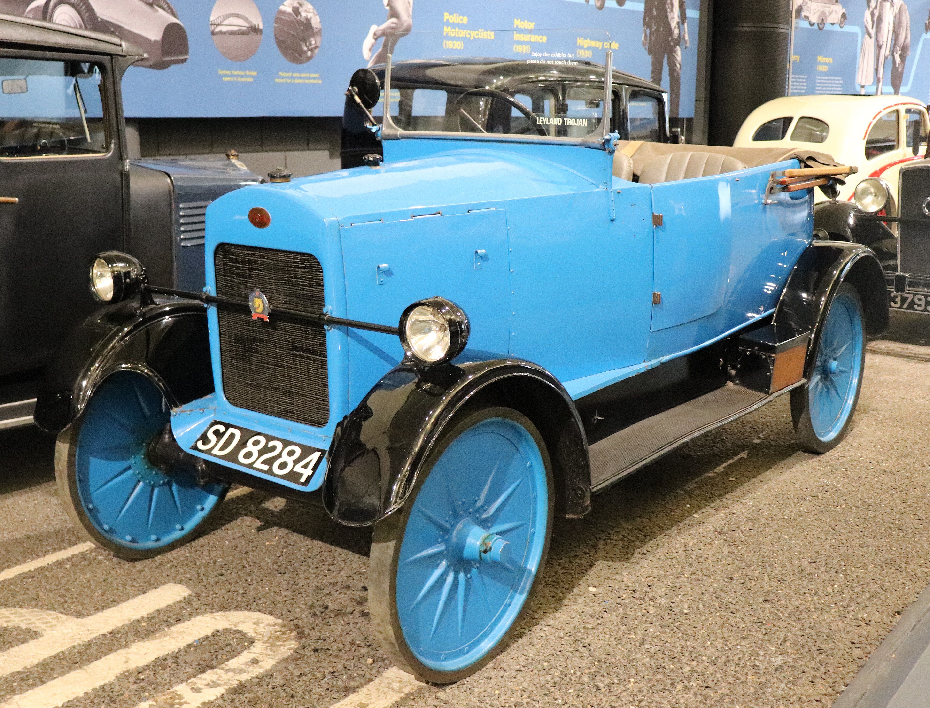 Blue 1924 Leyland-built Trojan Utility Car tourer, front three-quarter view, on museum display