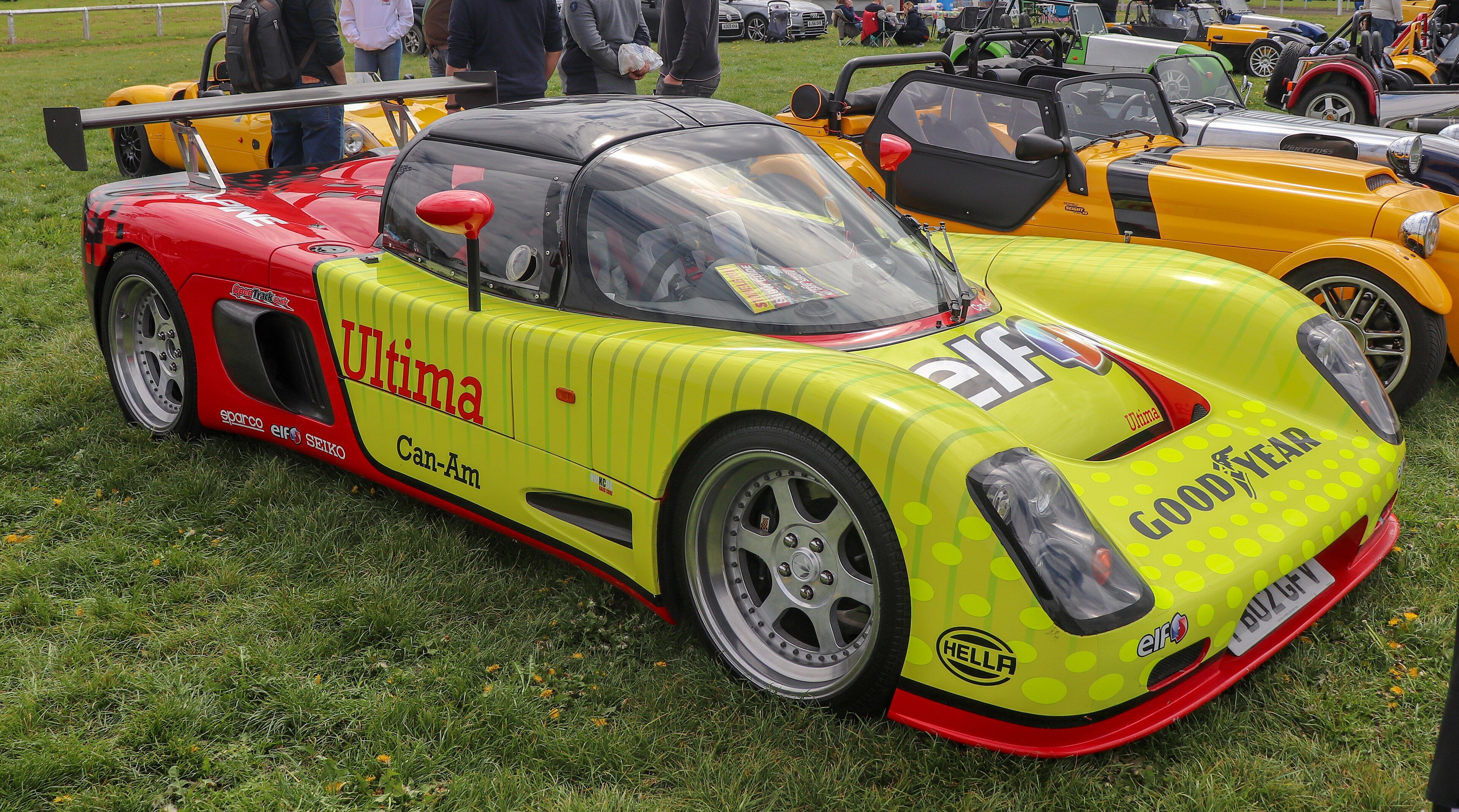 Yellow and red 2002 Ultima Can-Am 6.3 open-top racer, front three-quarter view