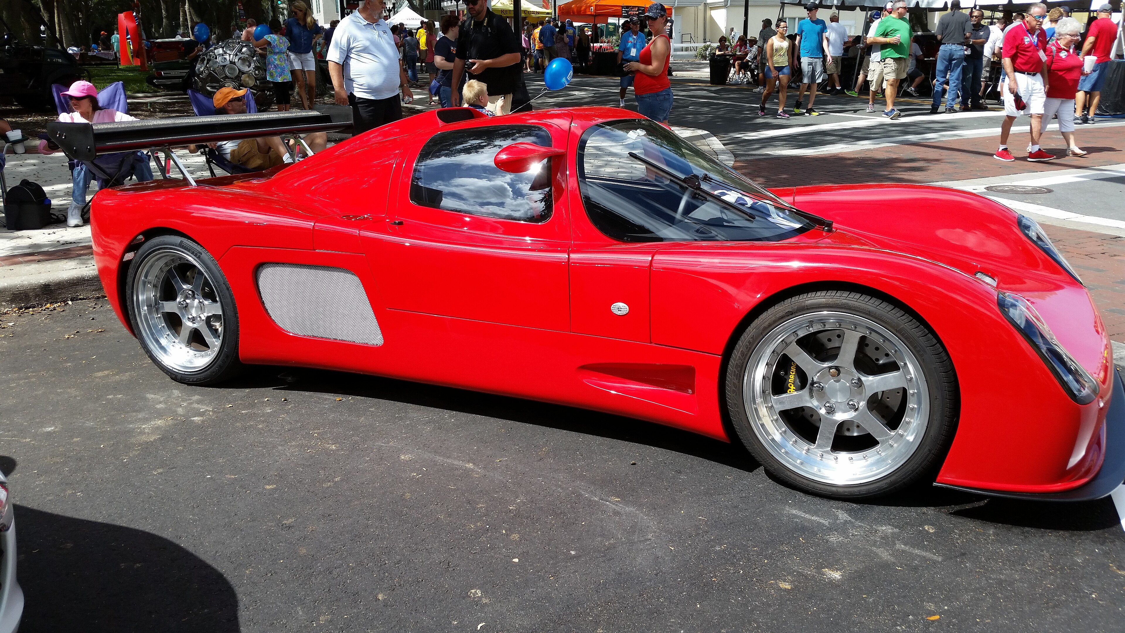 Red 2015 Ultima GTR at a street show, side profile view